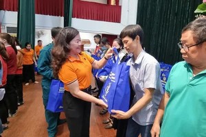 第五郡劳动联团主席黎氏碧幸向当地贫困劳工赠送礼物。（图：互联网）