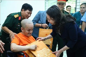 国家副主席武氏映春向一名落叶剂受害者赠送礼物。（图：越通社）