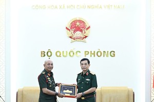 潘文江大将向穆罕默德·阿布·拉赫曼大将赠送纪念品。（图：人民军队报）