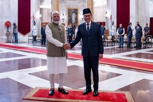 印度总理莫迪（左）与马来西亚首相安瓦尔握手合影。（图：互联网）