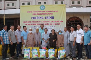 观音寺住持释女法平尼师与诸位华人热心人士向贫困者派发盂兰节礼物。