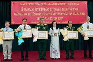 阮氏金蓉同志（右三）向荣获40年党龄纪念章的同志表示祝贺。（图：黄雄）