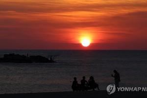 图为 8月23日，在江原道江陵市镜浦海水浴场，红日冉冉升起。（图：韩联社）