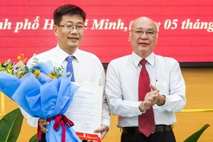 市委宣教处主任潘阮如奎（右）祝贺陈青松同志出任第八郡人委会主席一职。（图：草黎）