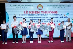 边和华人励学会主任黄友义向优秀生颁奖。（示意图：仁建）