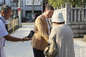 9月8日于东京都葛饰区，自民党前干事长石破茂（中央）身穿《寅次郎的故事》中主角的服装与行人握手。（图：共同社）