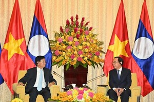 市委书记阮文年（右）会见老挝党中央总书记、国家主席通伦‧西苏里。（图：越勇）