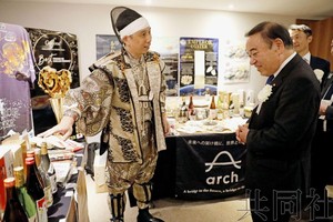 9月11日摄于巴西圣保罗，日本食材出口推介活动上，农相坂本哲志（右）来到介绍熊本县烧酒和食品的展位前。（图：共同社） 