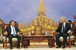 老挝革命人民党中央书记处书记、万象市委书记、市人民议会主席阿努哈普·图纳洛姆（右）会见越共中央委员、河内市人民委员会主席陈士青。（图：越通社）