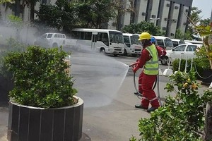 在尼日利亚阿布贾，工作人员在一处办公场所进行消毒作业。（图：新华社）