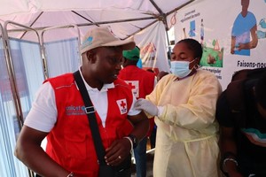 10月5日，在刚果（金）北基伍省首府戈马市一座医院内，医护人员为一名联合国儿童基金会工作人员接种猴痘疫苗。（图：新华社）