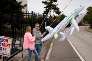 2024年10月11日，波音罢工工人在华盛顿州的生产工厂入口附近举着充气飞机。受到罢工影响，预计第三季度亏损将大幅增加，计划在未来几个月内在全球范围内裁员10%。(图：路透社）