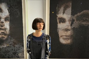 Ai-Da与自己创作的图灵肖像画合照。（图：Daily Mail）