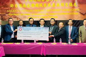 越南驻美国三藩市总领事馆总领事黄英俊（左四）接受旅美越南华人代表移交的赈灾捐款大支票。