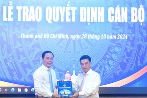 市人委会副主席阮文勇（右）向阮辉胜同志颁授《决定》。（图：市党部新闻网）