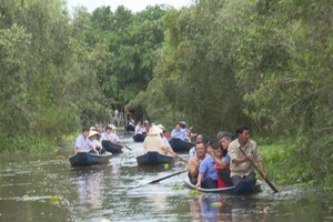 韩国代表团与隆安省领导在新立水上村生态旅游区体验划三叶船。（图：越通社）
