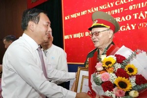 市人民议会常务副主席范成坚（左）高龄党员颁授党龄纪念章。（图：武平）