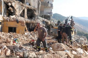 2024年11月6日，黎巴嫩民防成员在黎巴嫩巴尔贾以色列空袭中的现场搜寻生还者。（图：路透社）