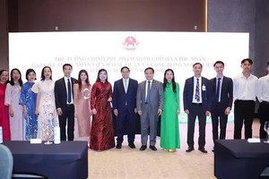 政府总理范明政和夫人同与会代表合影。（图：越通社）