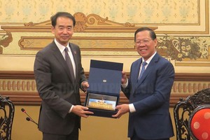 市人委会主席潘文迈（右）向中国驻越南大使何炜赠送礼物。（图：市党部新闻网）