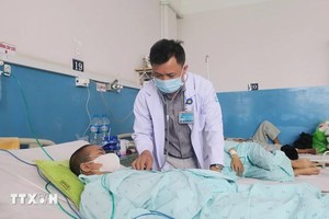 市热带病医院医生正在为一名麻疹患者查体。（图：越通社）