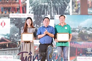 第十一郡人委会主席阮陈平（中）向摄影得奖者颁奖。