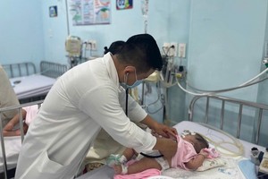 医生正在为一名麻疹患儿检查生命体征。（图：丹芳）