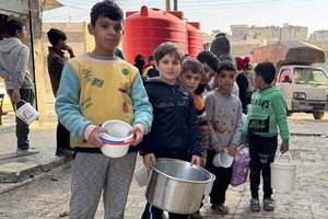 孩子们在叙利亚阿勒颇排队领取热餐。（图：联合国）