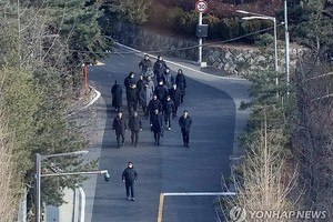 1月3日，在首尔市龙山区汉南洞的总统官邸内，高级公职人员犯罪调查处（公调处）侦查人员和警察走出官邸。公调处当天开始对尹锡悦执行拘留，但因遭到总统警卫处阻拦，认为无法继续执行，遂停止执行程序。 （图：韩联社）