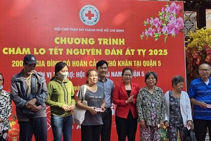 海南会馆理事长林明辉与市红十字会副主席邓氏明孝颁赠购物券给贫困者。