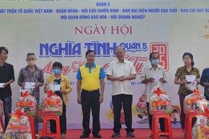 第五郡越南祖国阵线委员会主席黎晋才与穗城会馆理事长卢耀南向贫困户赠送礼物。