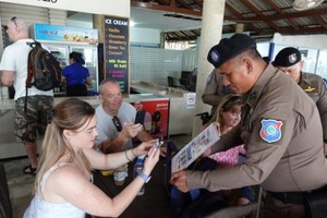 泰国警方宣布升级旅游安全保护措施。图为泰国旅游警员在苏梅岛，向外国游客介绍“泰国旅游警察”手机应用程式。（图：互联网）