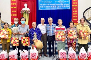 富顺公司经理杨顺龙与本报编委黎曰孟雄向贫困人家发送新年礼物。