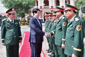 国家主席梁强同第九军区武装力量干部握手致意。