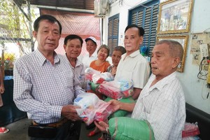 热心厂商杨庆文和业团主席李国强向老弱团员派发新年礼物。