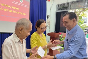 第十一郡高龄人会主席朱杞文向老人赠送礼物。