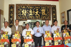 市委常委、市人委会常务副主席杨玉海（中）向穗城、义安、二府、海南、崇正、温陵会馆理事长们赠送贺年礼物。