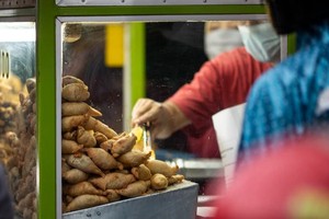 印度尼西亚雅加达的街头小贩在摊位上卖油炸食品。（图：UNICEF）