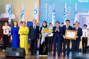 政府总理范明政向市国立大学颁授一等劳动勋章。（图：黄雄）