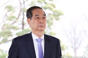 3月24日，韩国宪法裁判所（宪法法院）驳回国会针对国务总理韩悳洙发起的弹劾案。由此，韩悳洙立即恢复代总统职务。图为韩悳洙前往政府大楼上班。（图：韩联社）