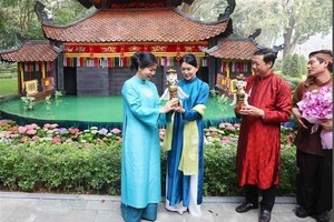 党中央总书记夫人与新加坡总理夫人共赏水上木偶戏。（图：越通社）