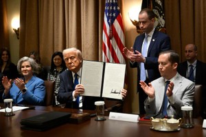 3月25日，特朗普展示他签署的行政命令。（图：AP）