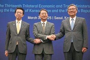 图为日本经济产业大臣武藤容治（左起）、韩国产业通商资源部长官安德根、中国商务部部长王文涛握手合影。（图：AFP）