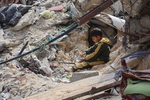 以色列在3月18日恢复对加沙的空袭，结束了持续数周的短暂停火。图为一加沙男童在建筑废墟中玩耍。（图：法新社）