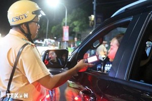 执勤交警正在对一名司机进行呼气式酒精测试。（图：越通社）