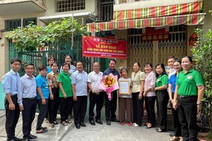 郡、坊领导和庆云南院住持周华邦向一贫困户移交修缮“温情屋”工程。