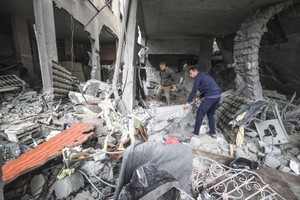 在加沙地带北部的杰巴厘耶难民营，民众查看以军袭击后的废墟。（图：新华社）