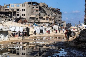 4月15日，加沙地带，人们从被摧毁的建筑旁走过。（图：互联网）