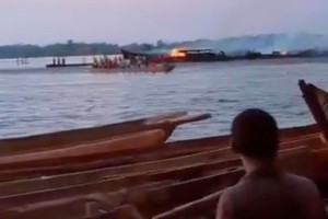 民众在岸上目睹木船着火。（图：路透社）