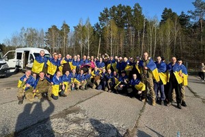 获释的乌克兰军人披上国旗合照。（图：路透社）